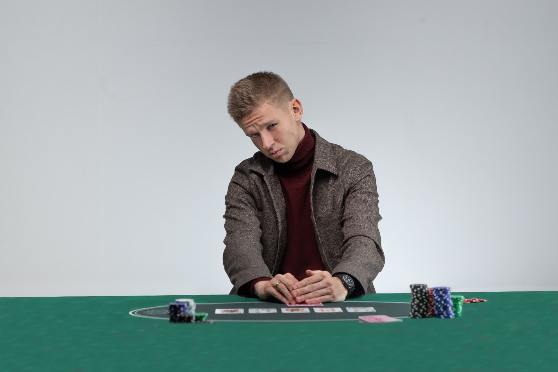 Player at a green poker table in a studio set for a gaming campaign